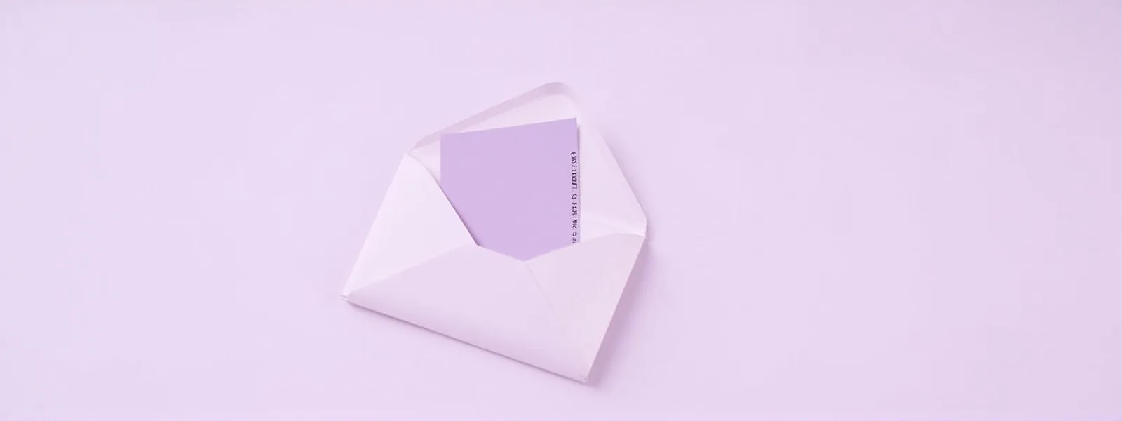 Wide editorial banner of an opened gift envelope on pale lilac background with a violet ticket stub visible