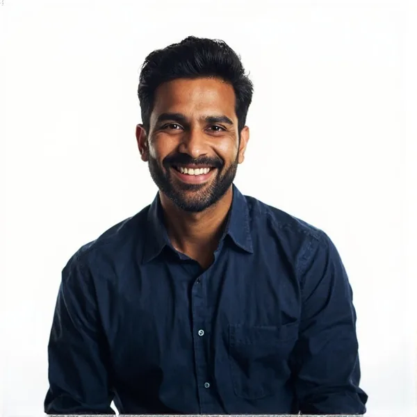 Indian male sports journalist professional headshot on a pale lilac background, navy shirt