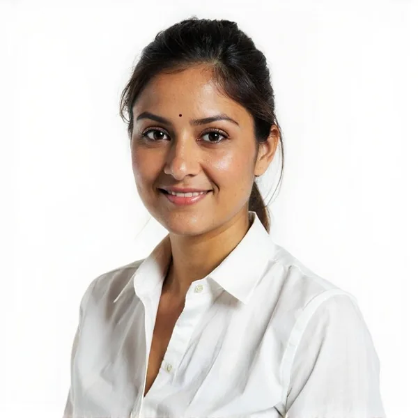 Indian female cricket analyst professional headshot on a pale lilac background, white shirt